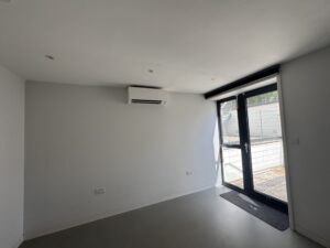 Wall-mounted air conditioning unit in a ground floor room with garden doors in Camden