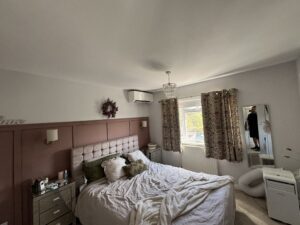 Wall-mounted air conditioning unit above the bed in a Camden main bedroom