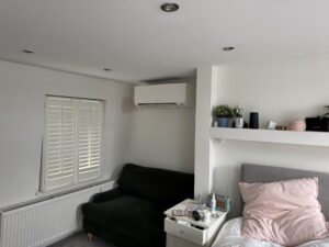 Wall-mounted air conditioning unit above the window in a Chelsea bedroom