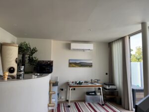 Wall-mounted air conditioning unit in a bright living and work space in Teddington